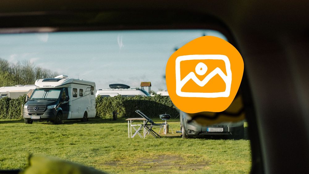 Blick aus der Heckklappe auf einen ruhigen Campingplatz. 